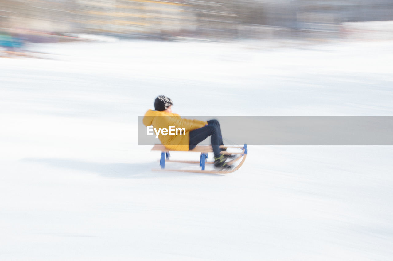 Side view of person riding motorcycle on snow