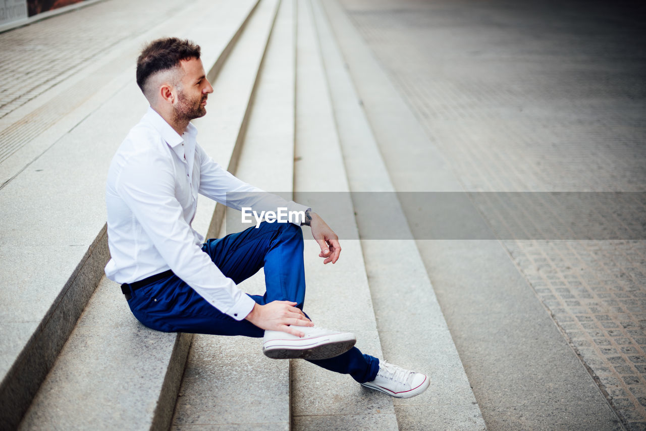 Side view of young man on staircase