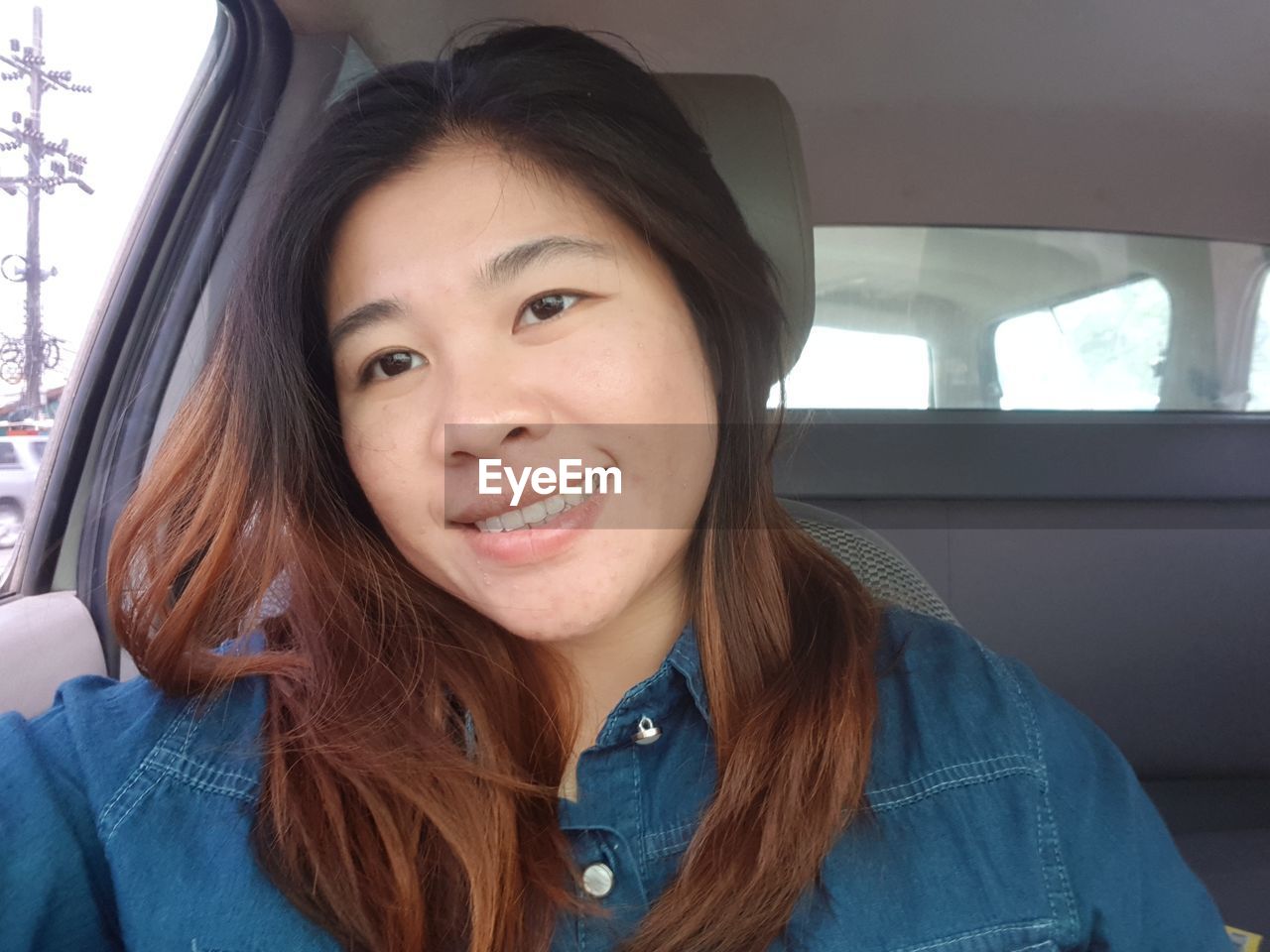 PORTRAIT OF SMILING WOMAN IN CAR