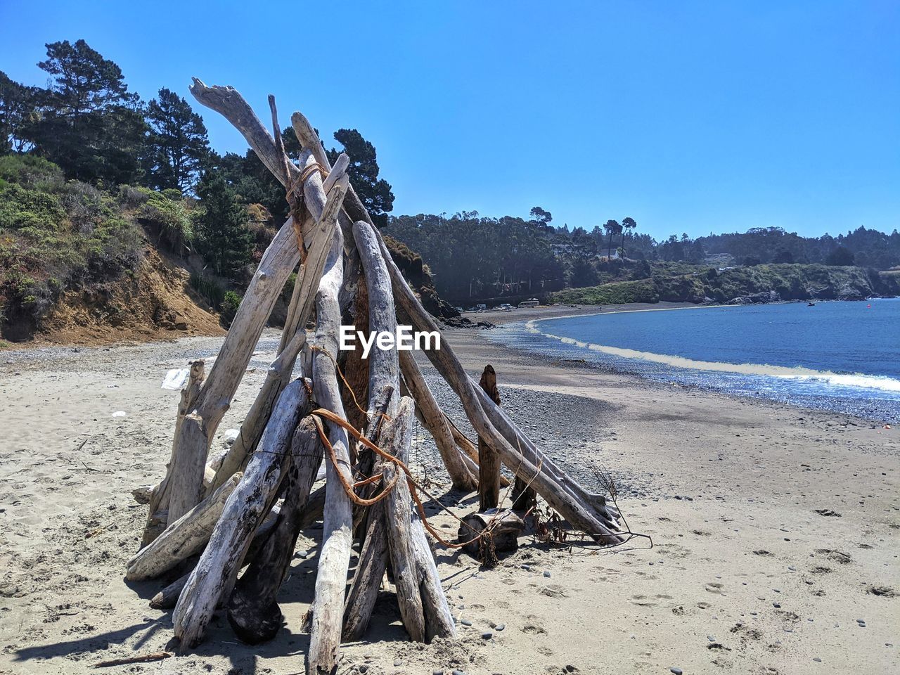 DRIFTWOOD ON BEACH AGAINST SKY