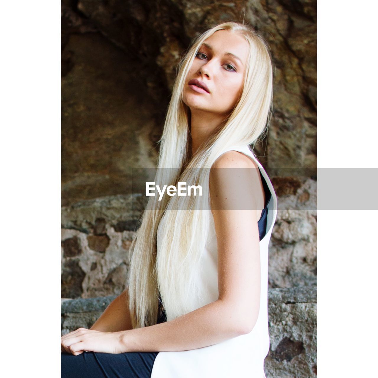 Portrait of beautiful young woman against wall