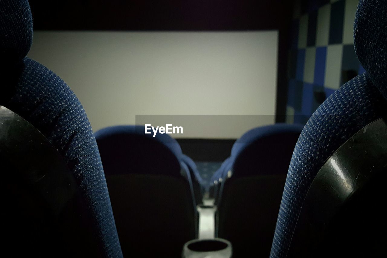 Close-up rear view of cropped chairs in auditorium