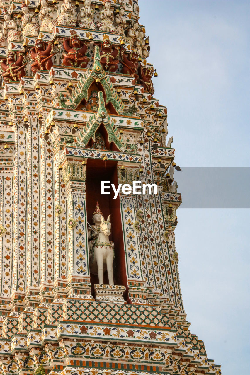 LOW ANGLE VIEW OF STATUE AGAINST TEMPLE BUILDING