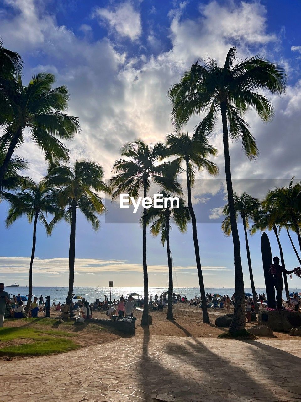 palm tree, tropical climate, sky, tree, sea, water, beach, land, nature, cloud, plant, vacation, coast, ocean, trip, body of water, holiday, beauty in nature, travel destinations, coconut palm tree, scenics - nature, shore, travel, sand, tranquility, tourism, sunlight, tropics, outdoors, tropical tree, tranquil scene, idyllic, environment, bay, group of people, horizon over water, relaxation, tourist, island, horizon, blue, leisure activity, day, walkway, summer, transportation, sunset, landscape, coastline, lifestyles, shadow, nautical vessel, tourist resort