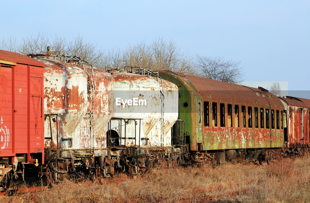 Old abandoned freight trains against clear sky