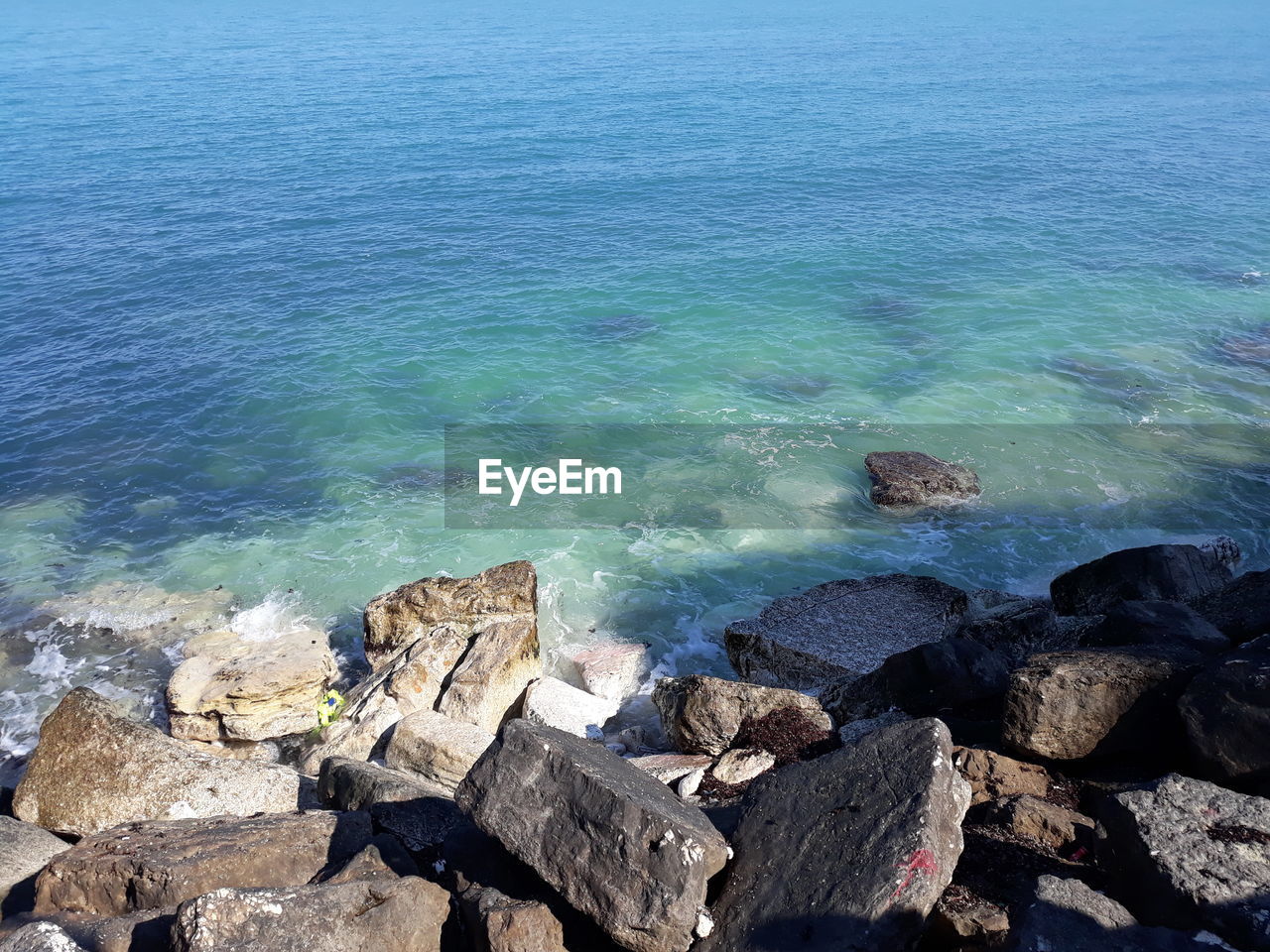 High angle view of rocks on sea shore