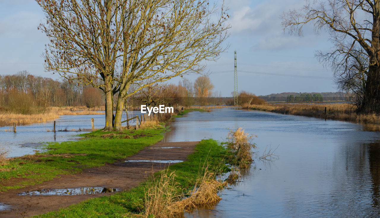 river, water, tree, plant, reflection, waterway, sky, nature, autumn, wetland, pond, environment, no people, beauty in nature, marsh, rural area, landscape, scenics - nature, body of water, tranquility, bare tree, cloud, grass, accidents and disasters, outdoors, flood, day, stream, tranquil scene, reservoir, floodplain, shore, land, non-urban scene, social issues, travel destinations, travel, architecture