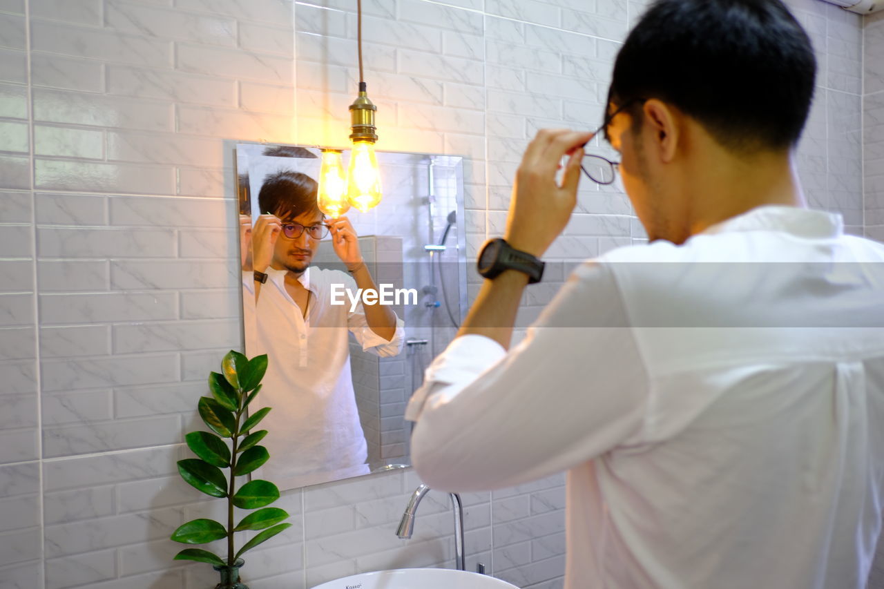 Man finishing dressing in bathroom