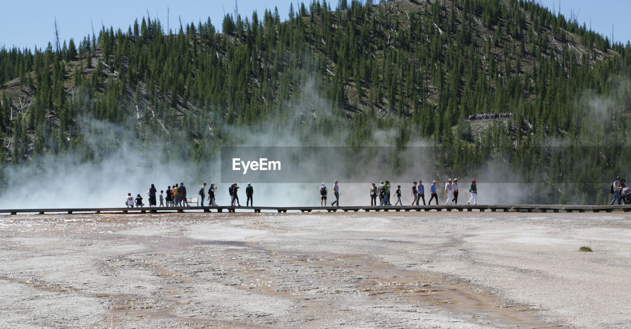 People at yellowstone national park against sky