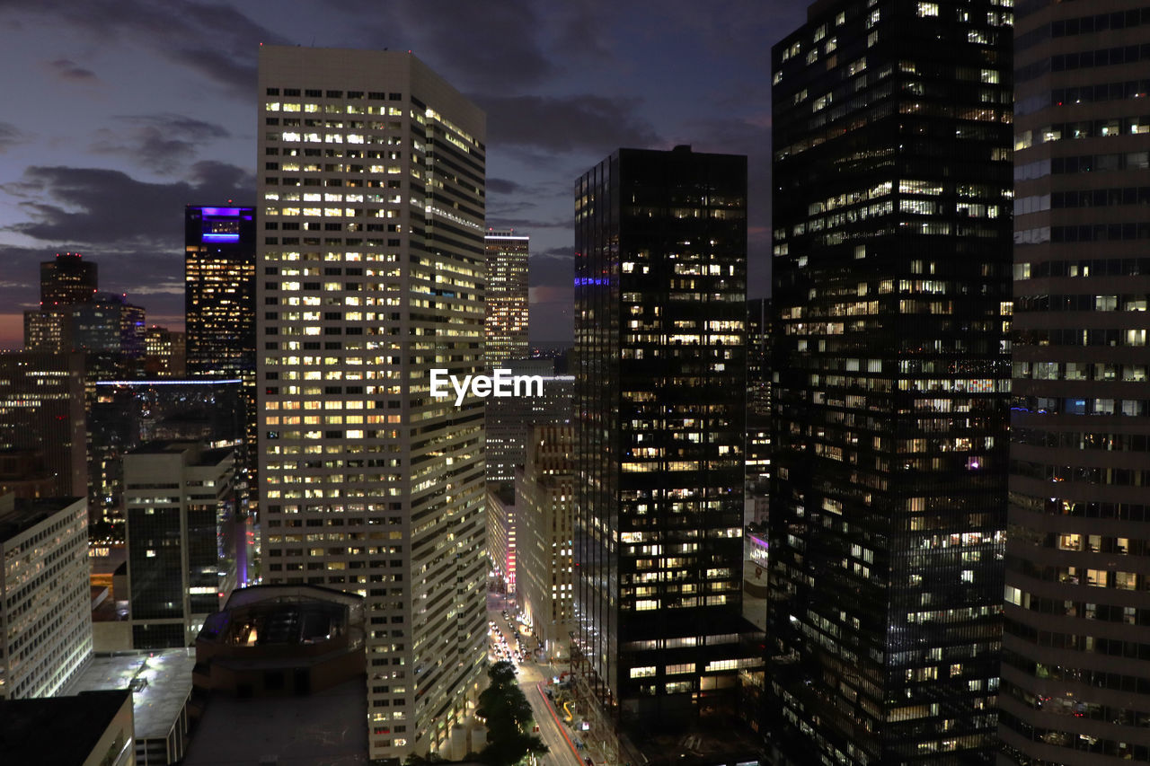 ILLUMINATED BUILDINGS IN CITY AGAINST SKY AT NIGHT