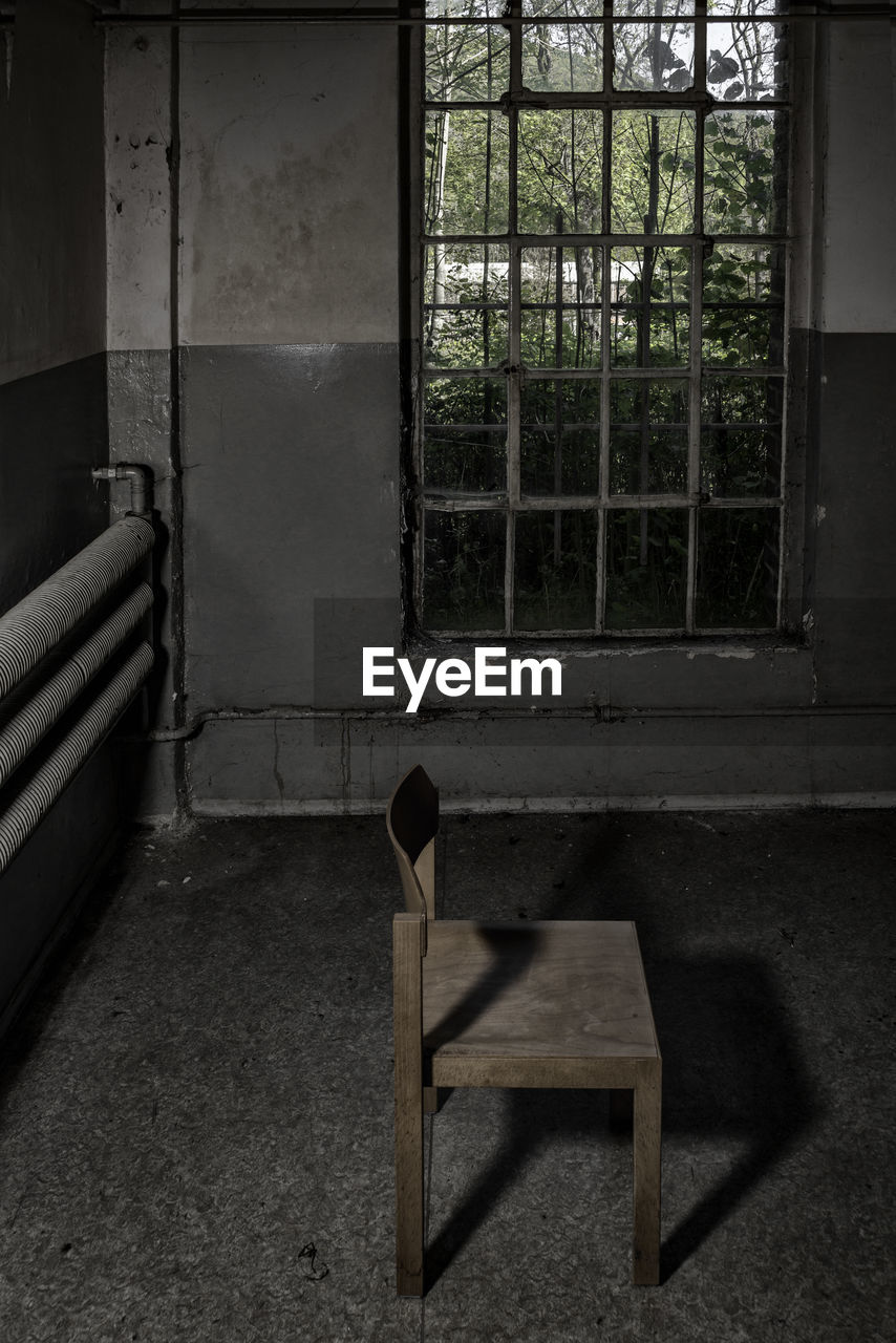 Chair in prison cell against window