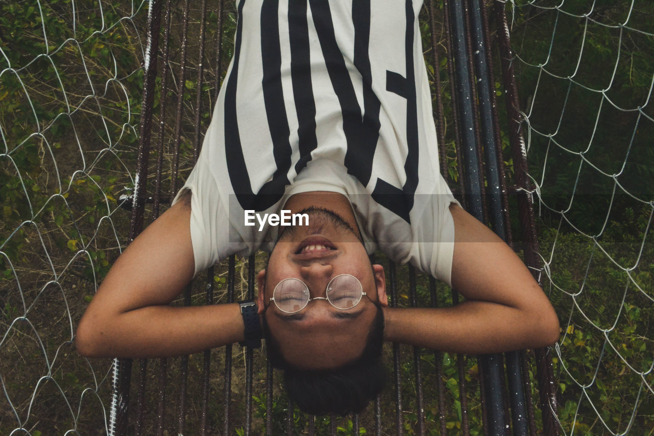 Directly above shot of young man sleeping on footbridge