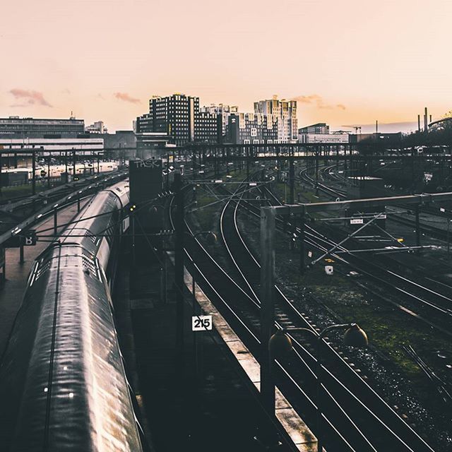 RAILROAD TRACKS IN CITY AT SUNSET