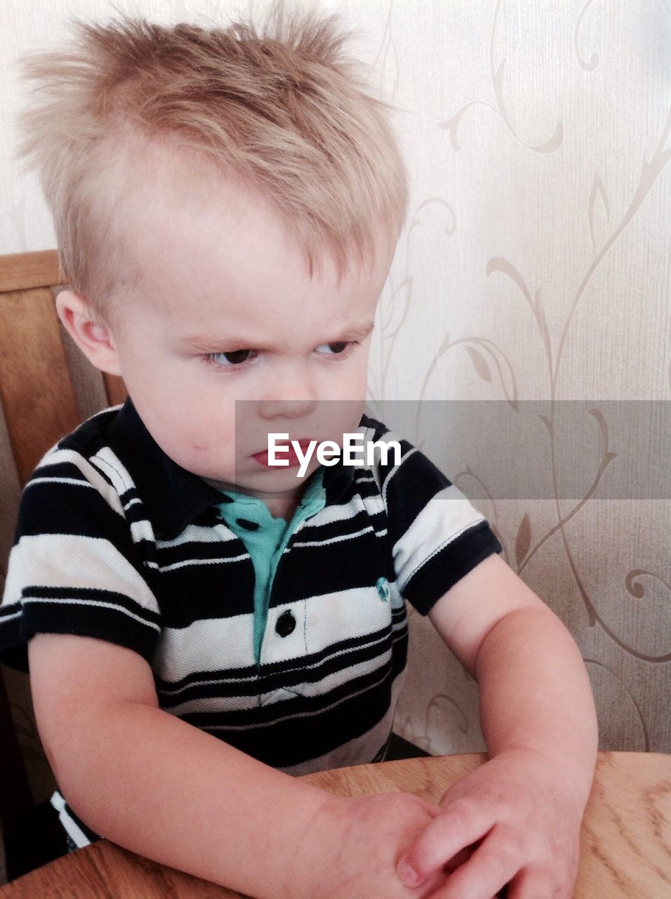 Angry boy sitting at table