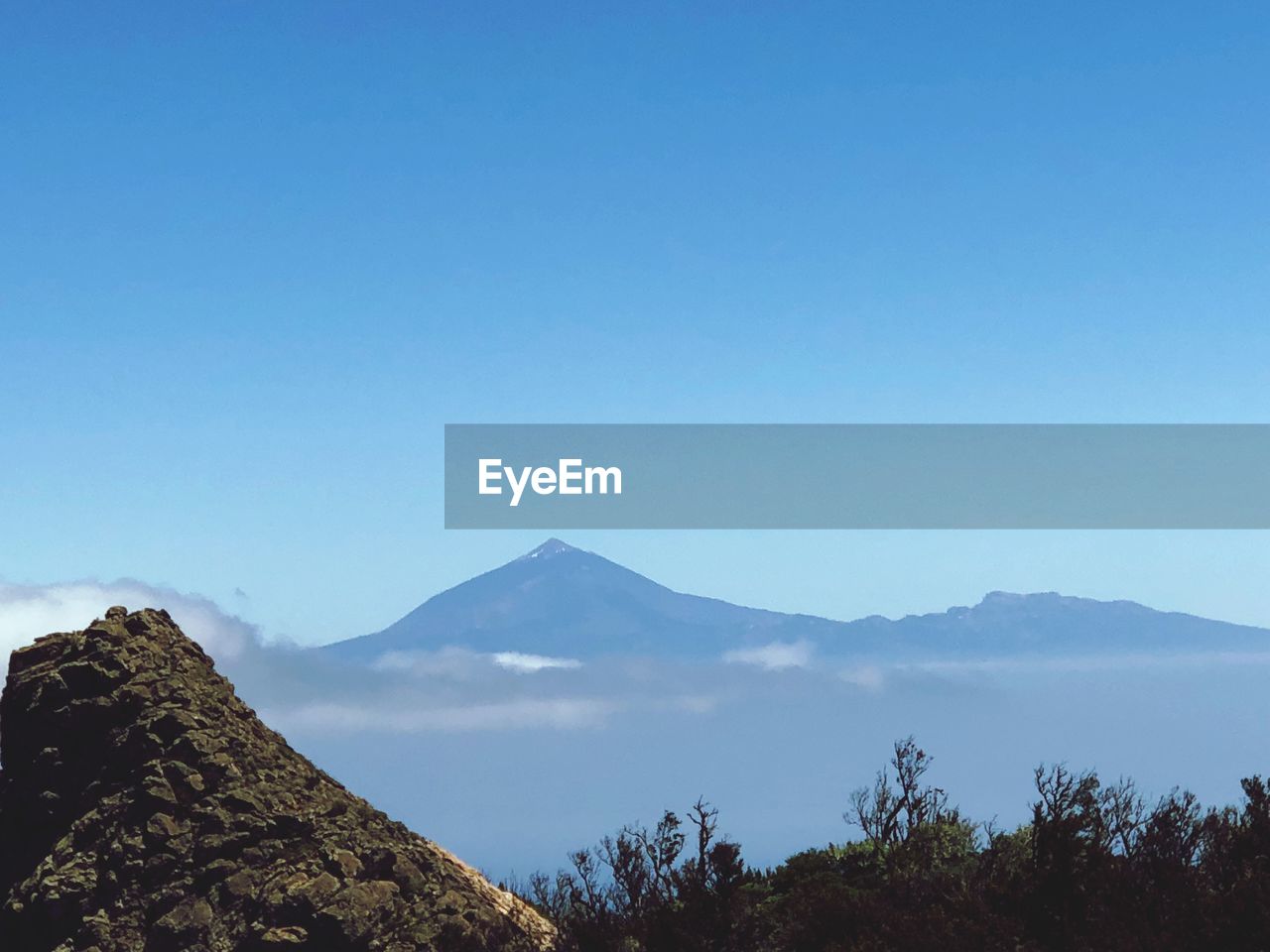 Scenic view of mountains against clear blue sky