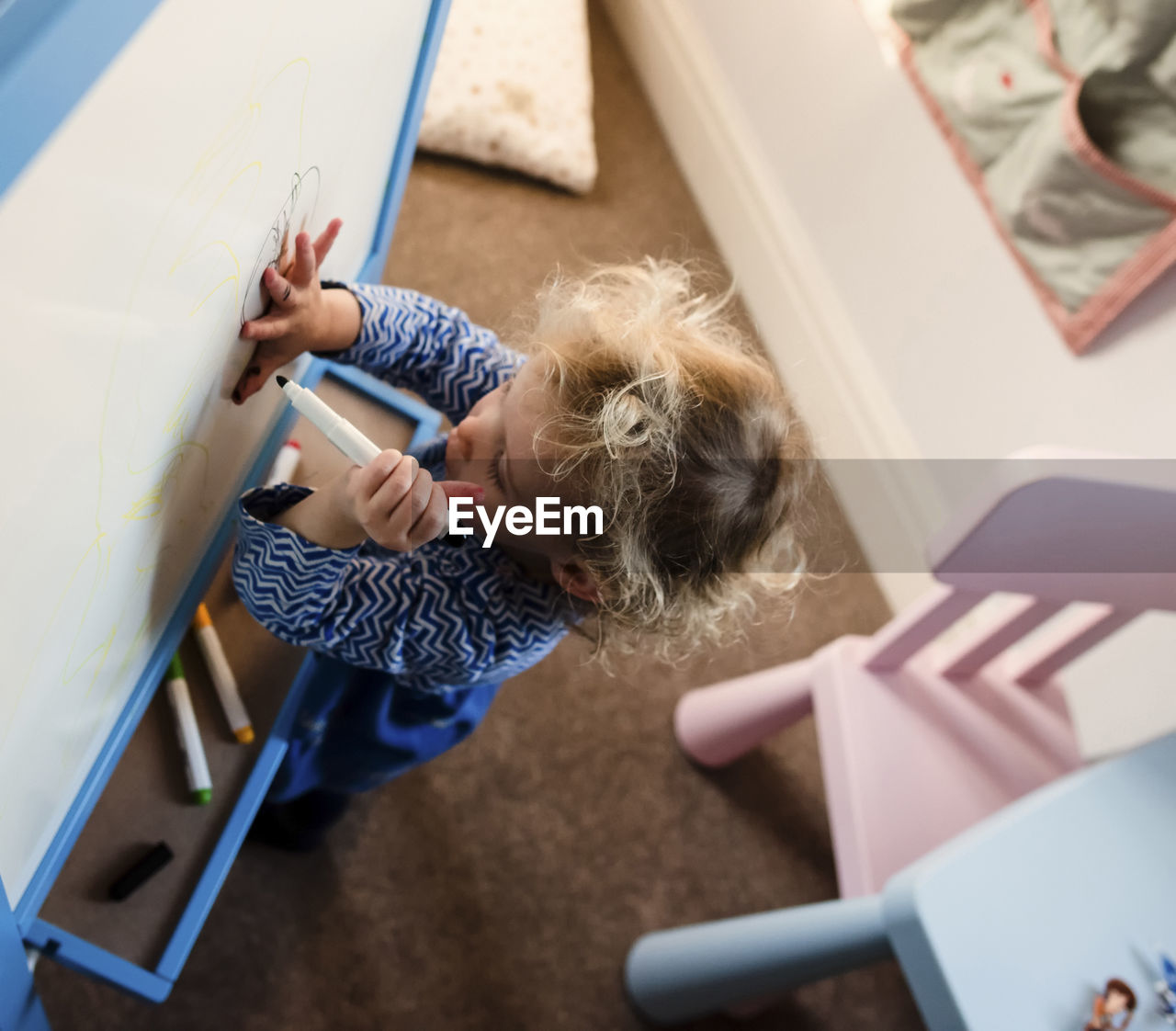 High angle view of girl drawing on canvas at home