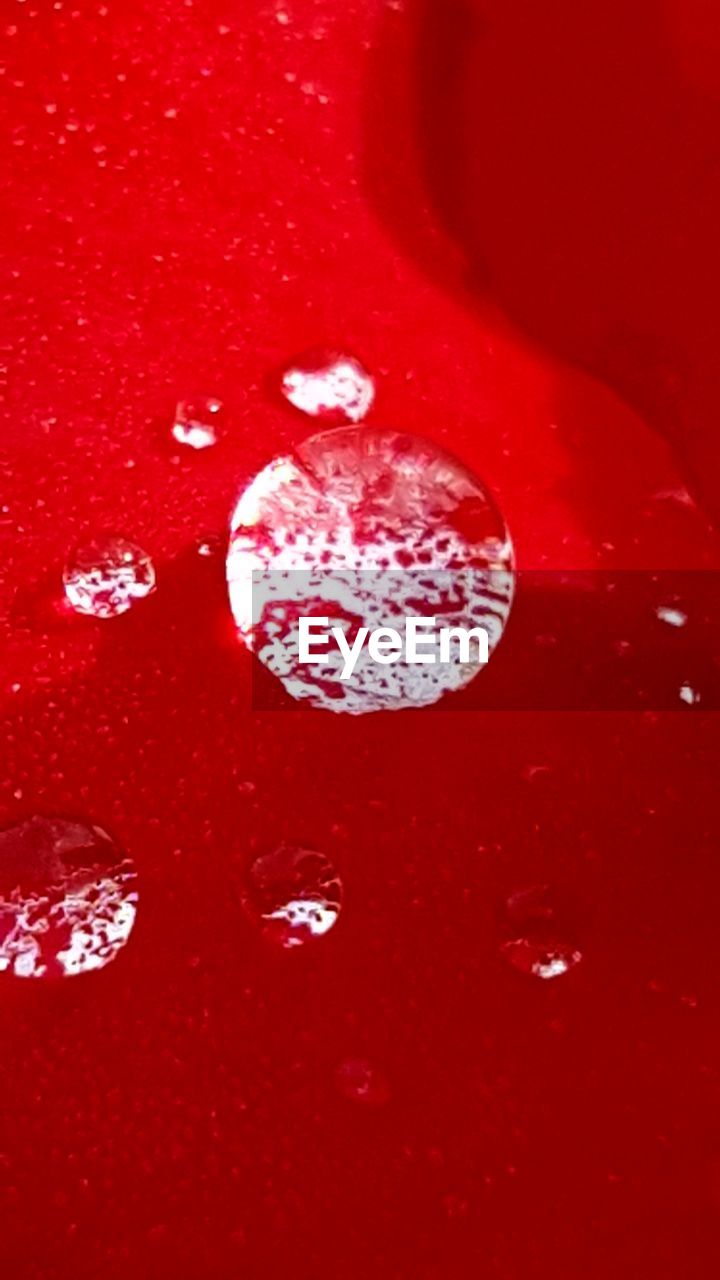 Full frame shot of droplets on red table
