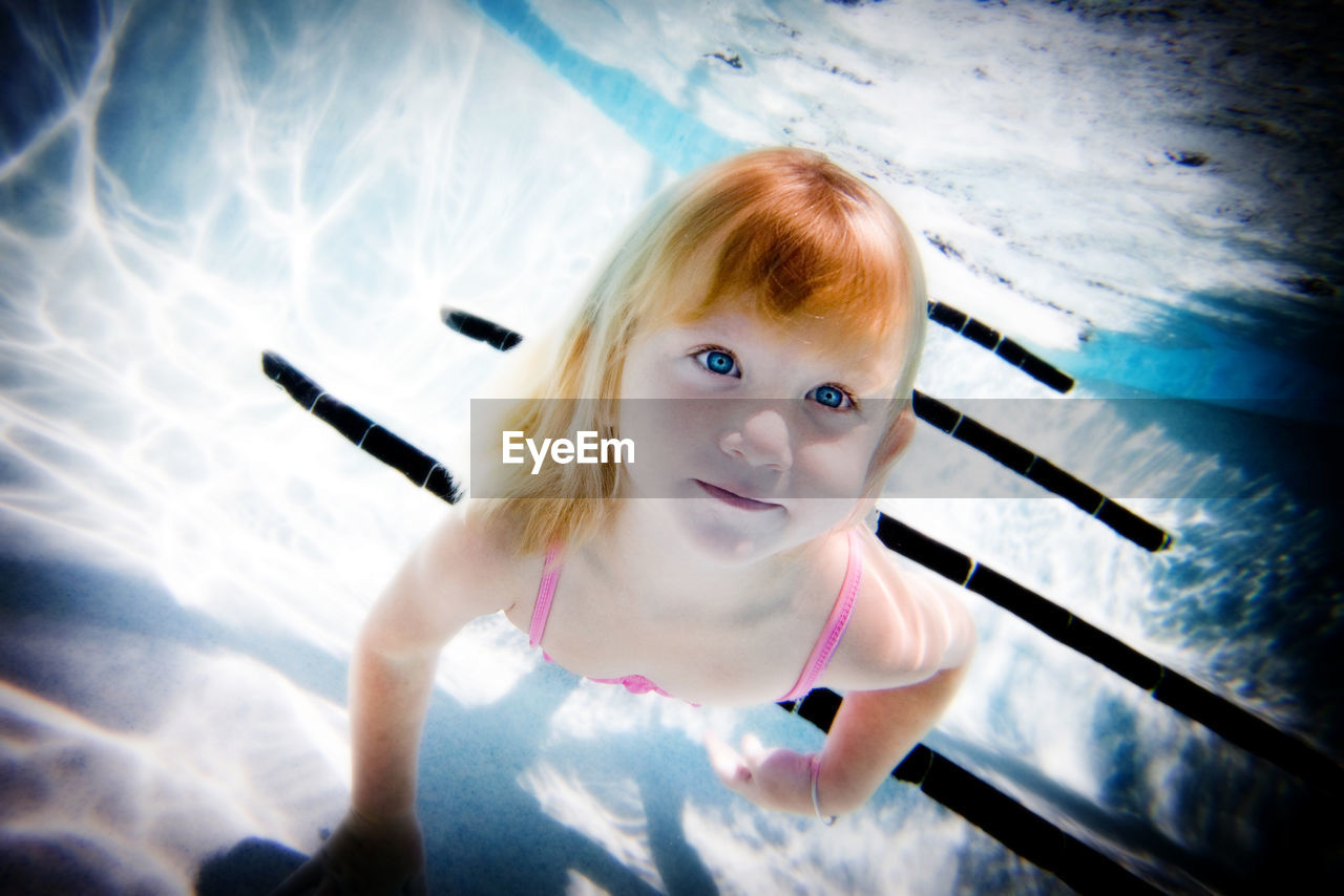 Portrait of cute girl swimming in pool