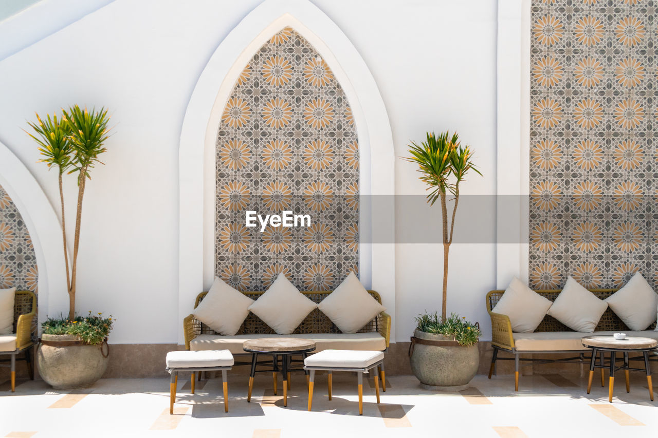 Arabian style terrace exterior with sofas, tables, stools and pillows