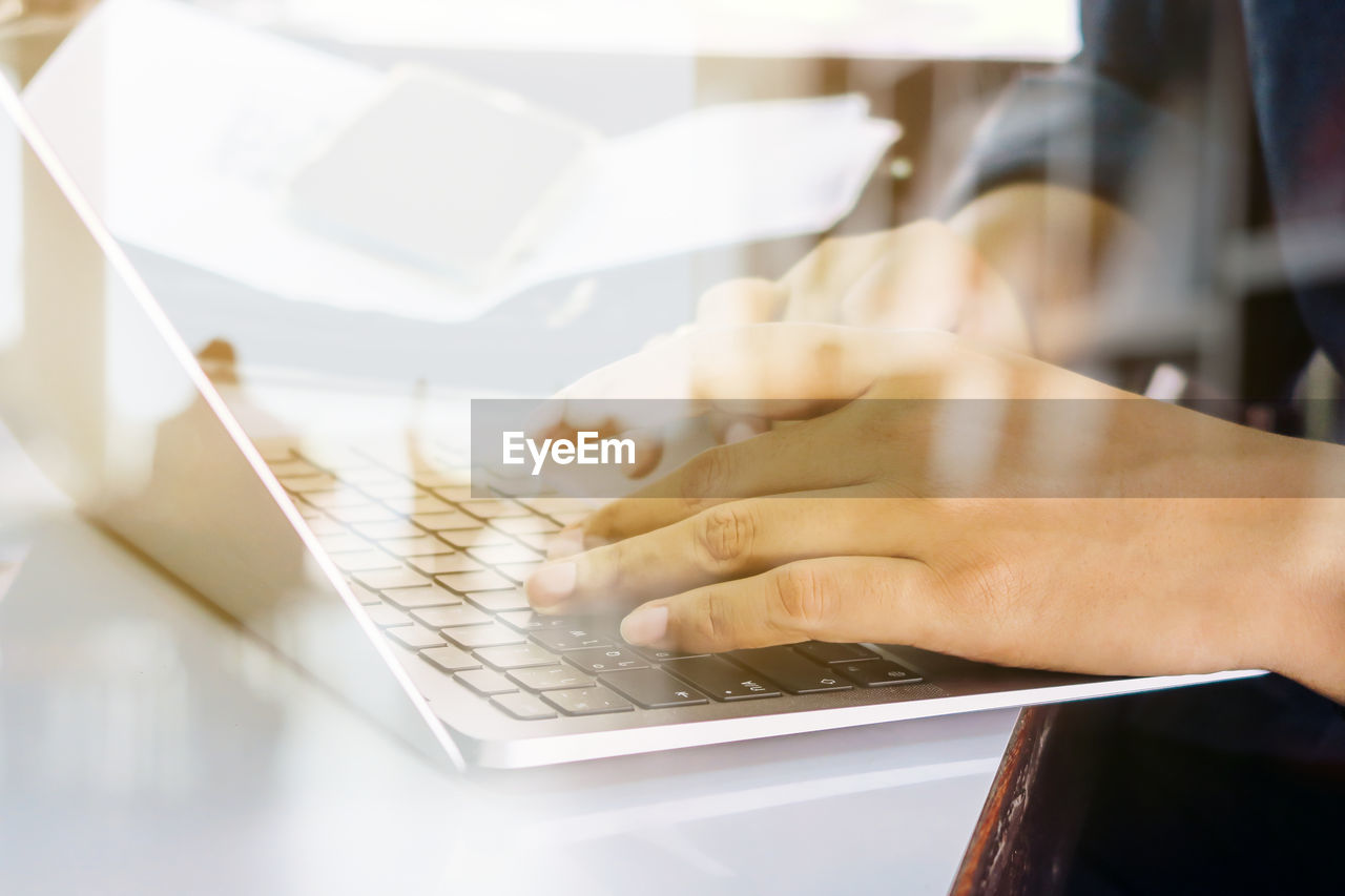 Close up image of man typing on laptop keyboard