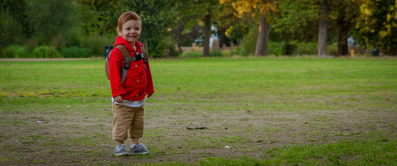 Full length of boy standing on grassy field in park