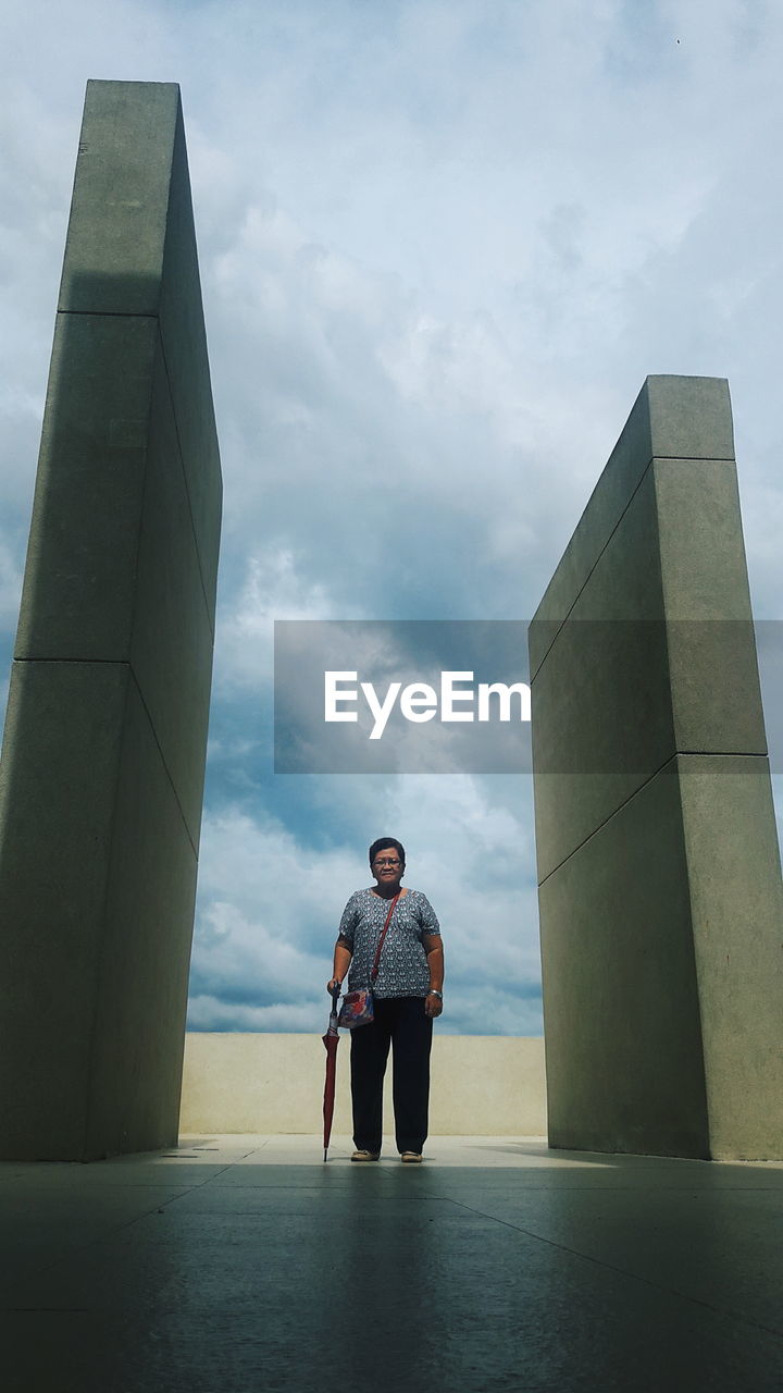 PORTRAIT OF TWO MEN STANDING ON BRIDGE AGAINST SKY