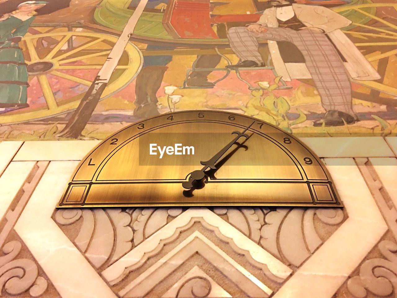 LOW ANGLE VIEW OF CLOCK ON PATTERNED WALL