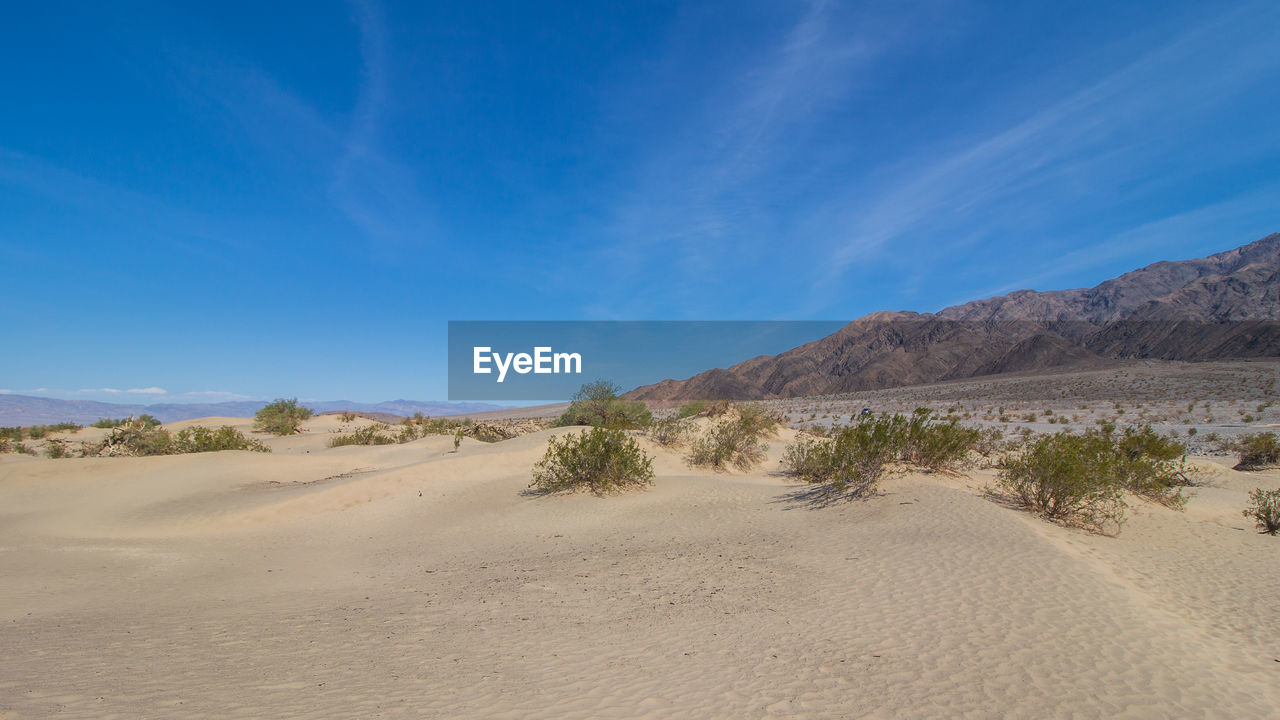 Scenic view of desert against blue sky