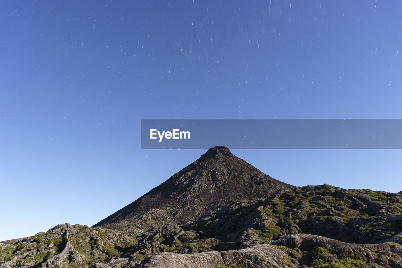 Low angle view of mountain against clear blue sky, top of pico island volcano