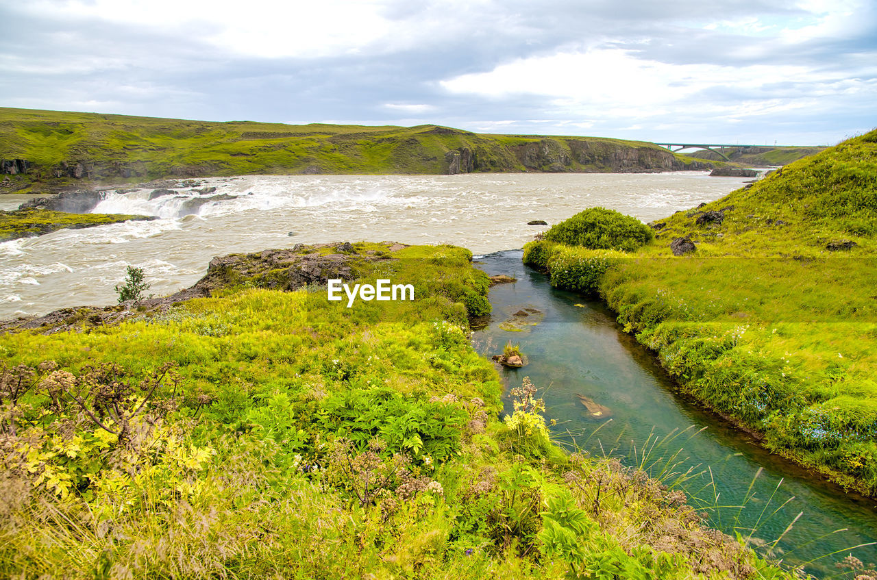 HIGH ANGLE VIEW OF RIVER AGAINST SKY