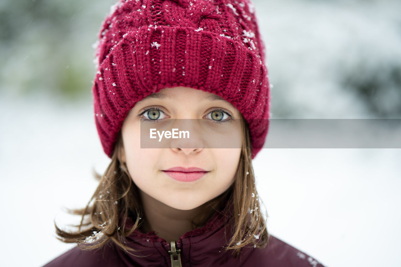 CLOSE-UP PORTRAIT OF A YOUNG WOMAN IN SNOW