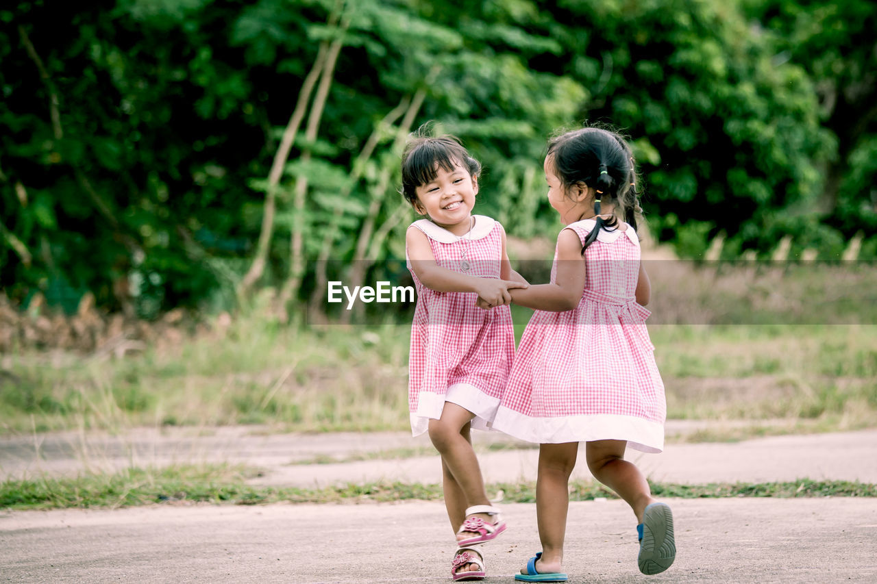 Twin sisters playing at public park