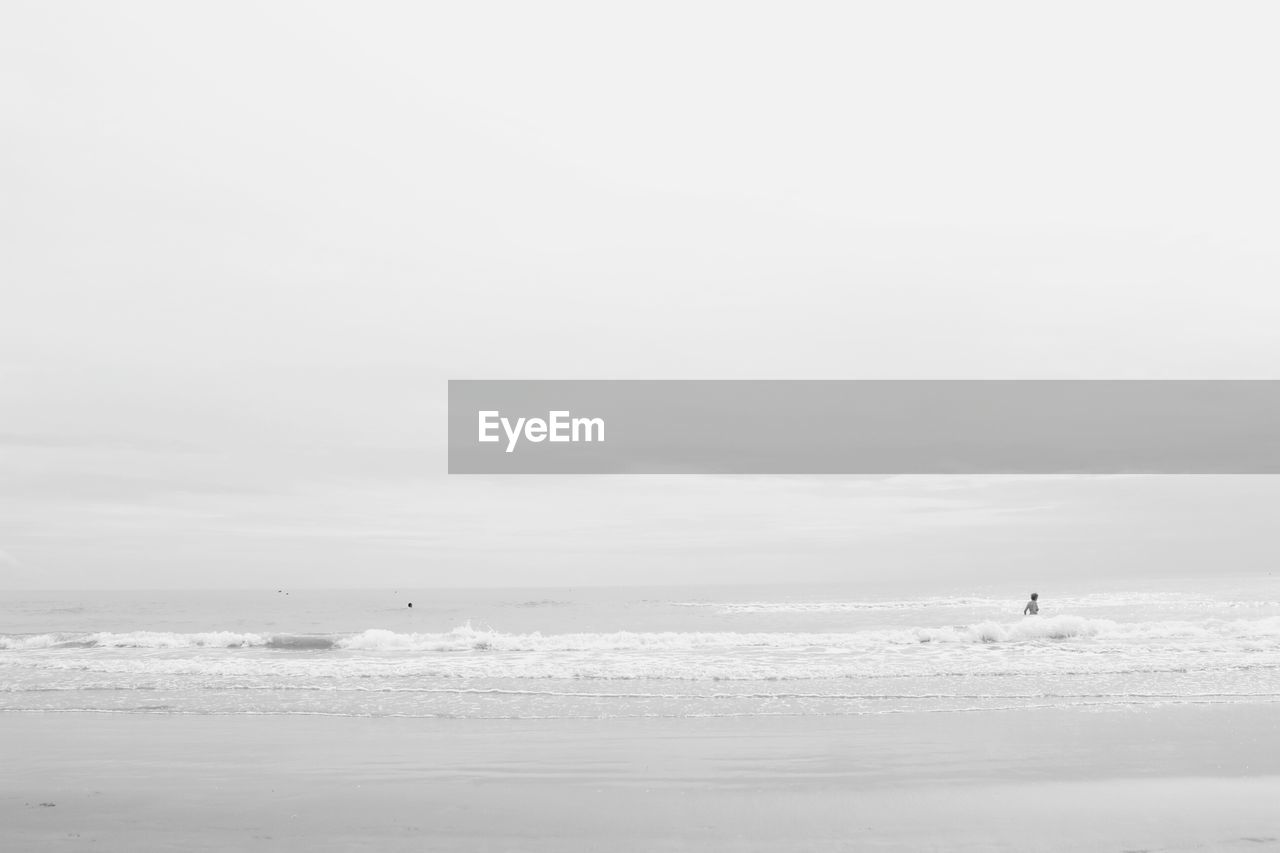 PEOPLE ON BEACH AGAINST SKY