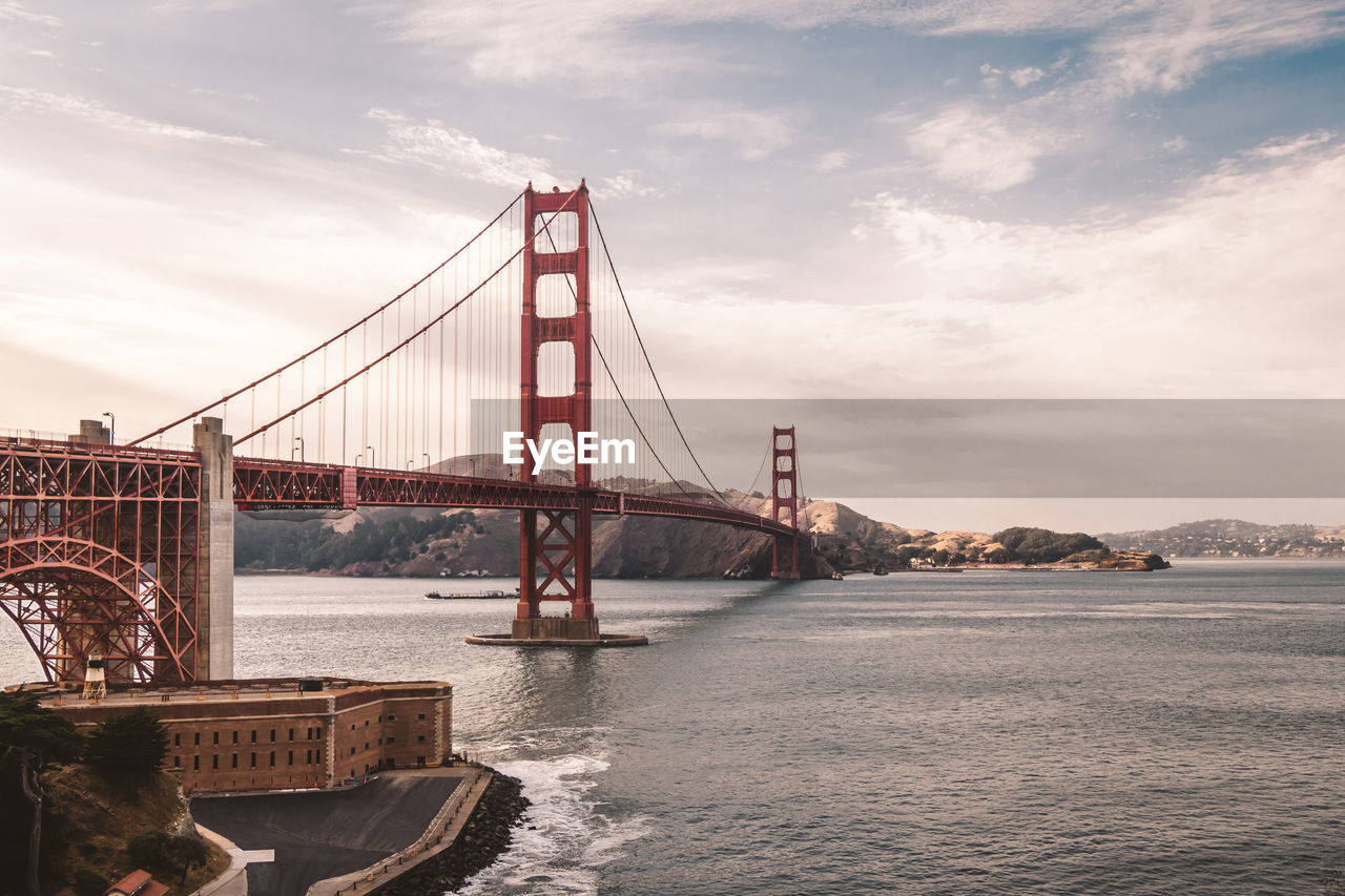 View of suspension bridge against cloudy sky