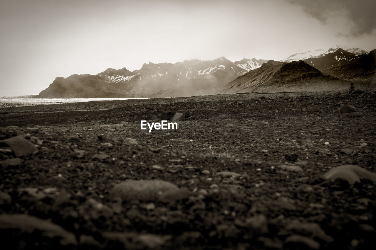 Scenic view of field and mountains against sky