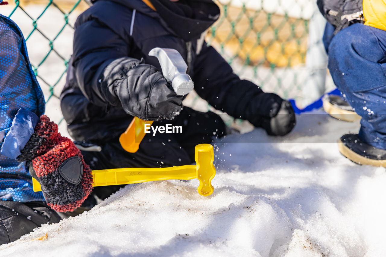 LOW SECTION OF PEOPLE PLAYING ON SNOW