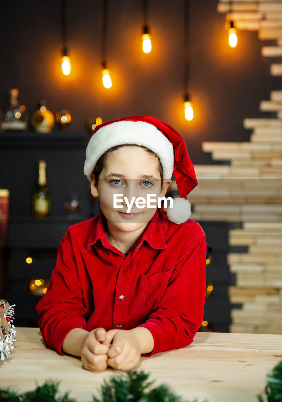 Happy funny child boy in red christmas shirt near christmas tree