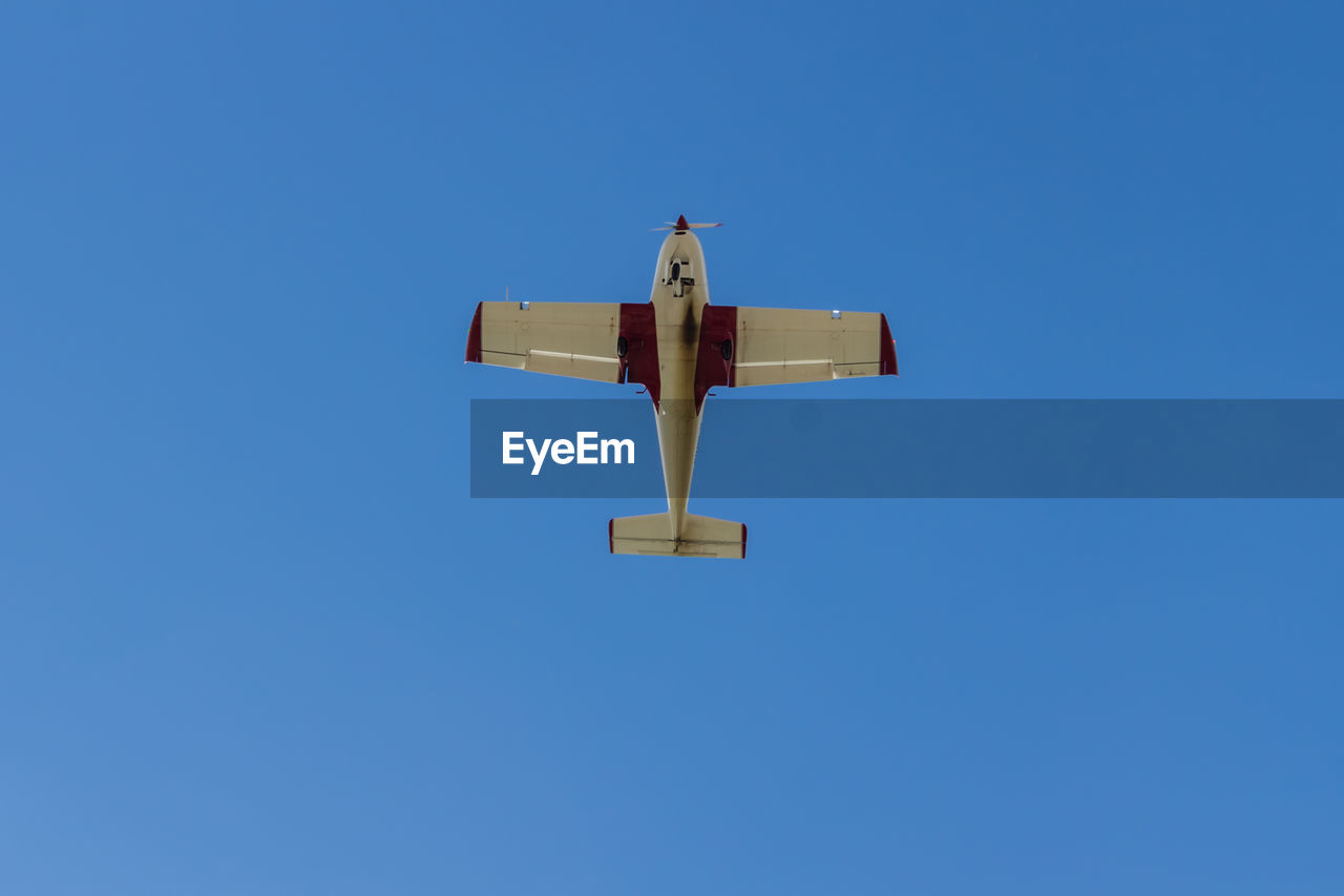 Directly below shot of airplane flying in clear blue sky