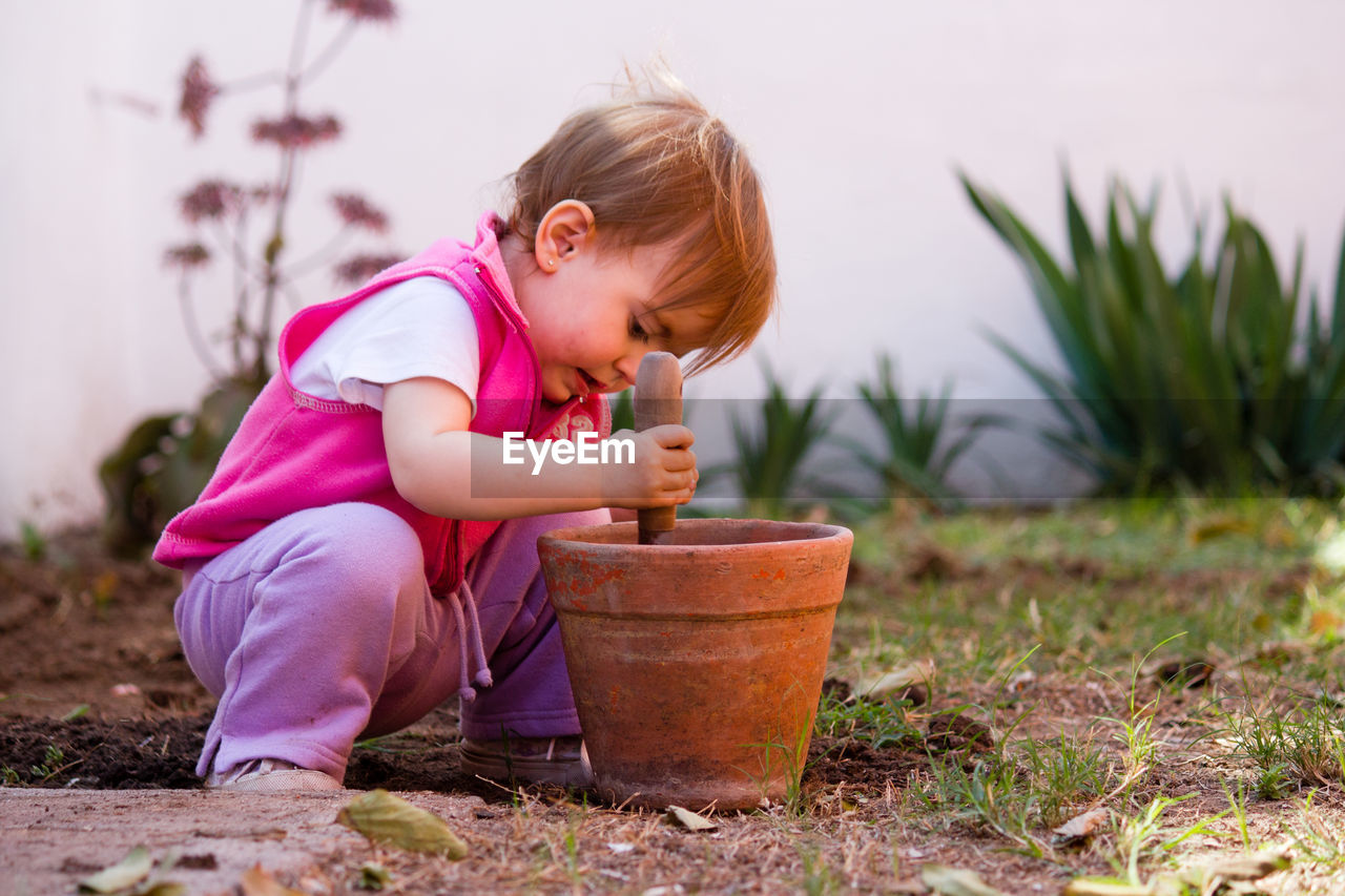 Cute girl digging in flower pot