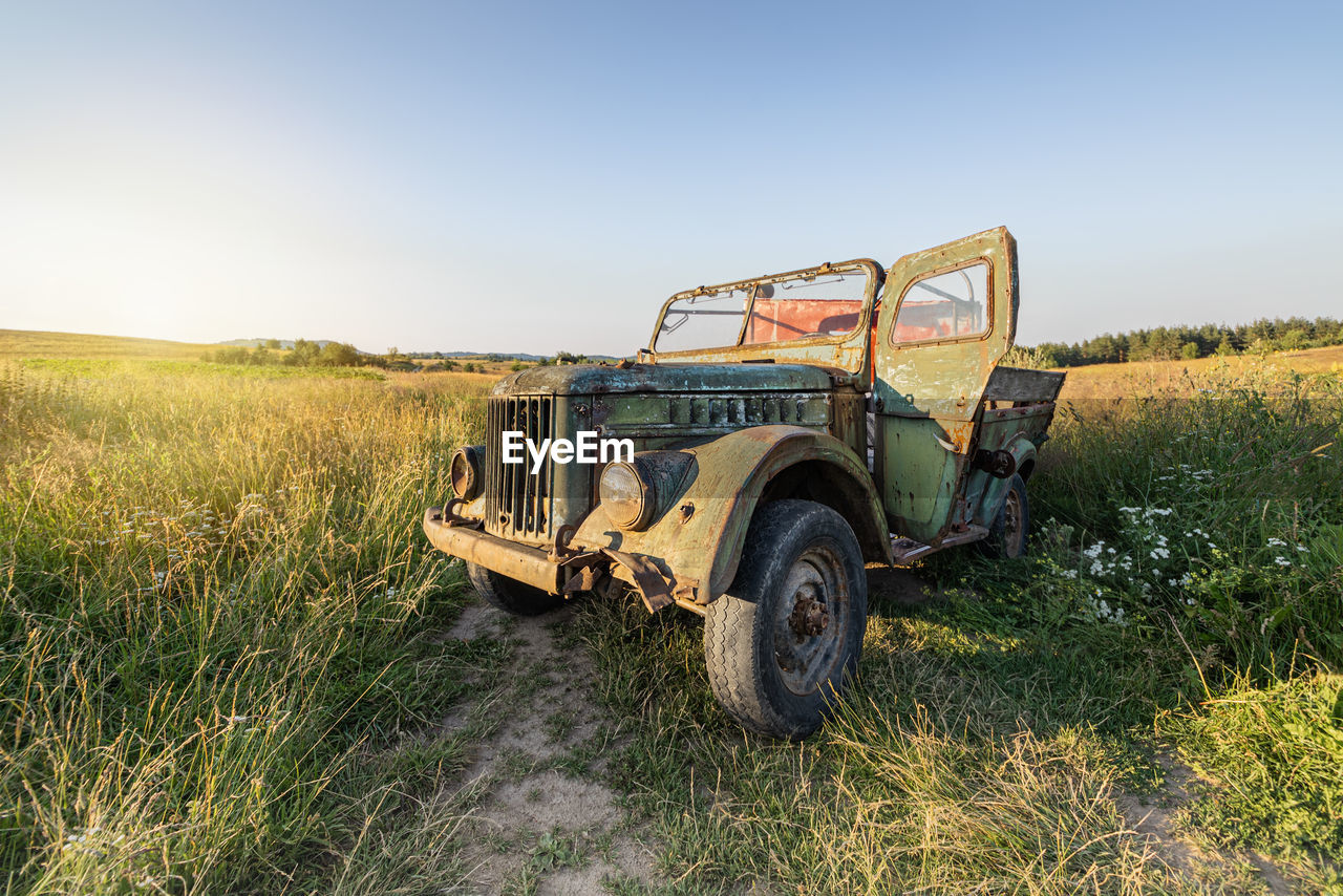 Abandoned vintage truck on field against clear sky