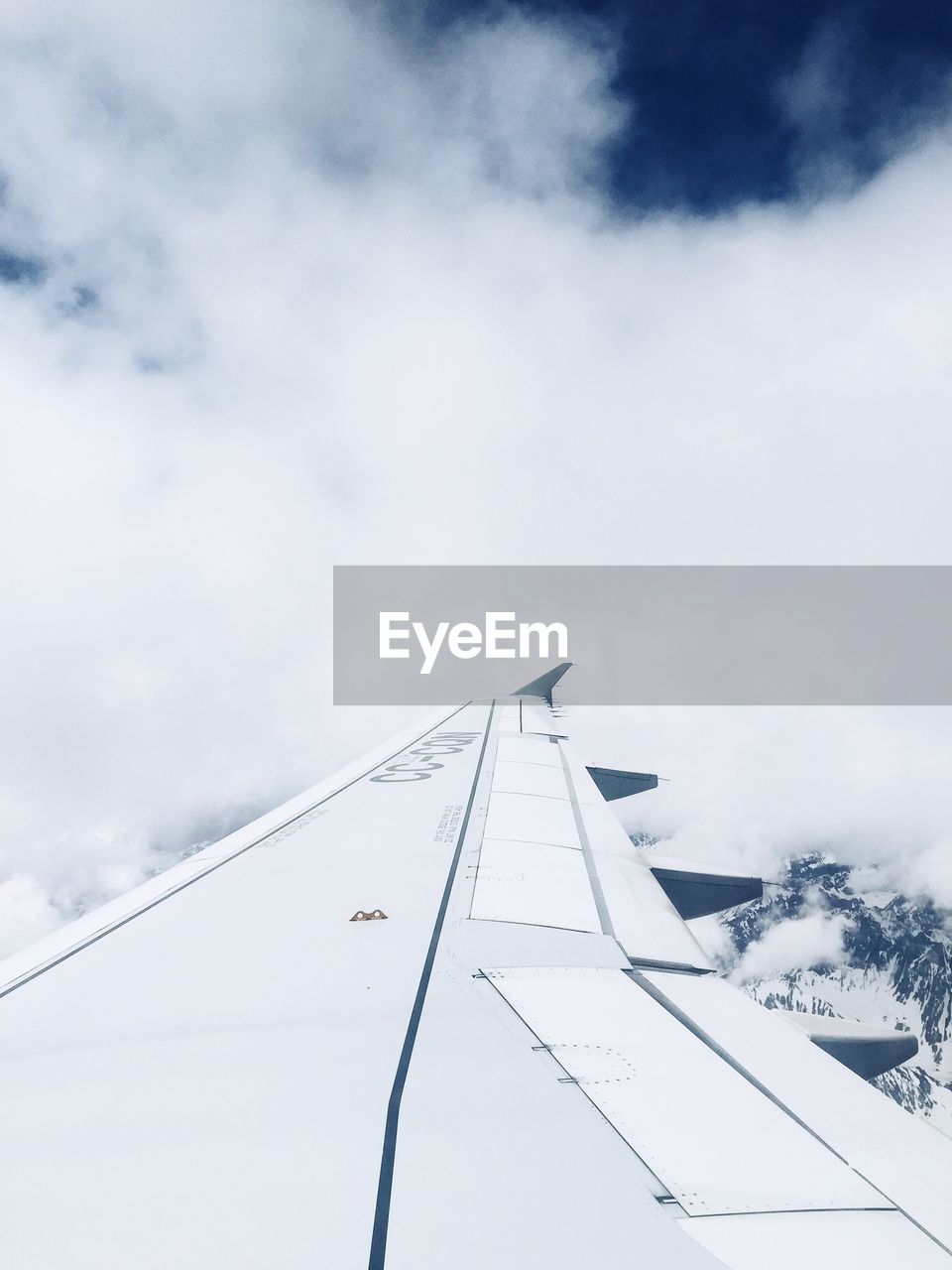 Snow covered landscape against cloudy sky