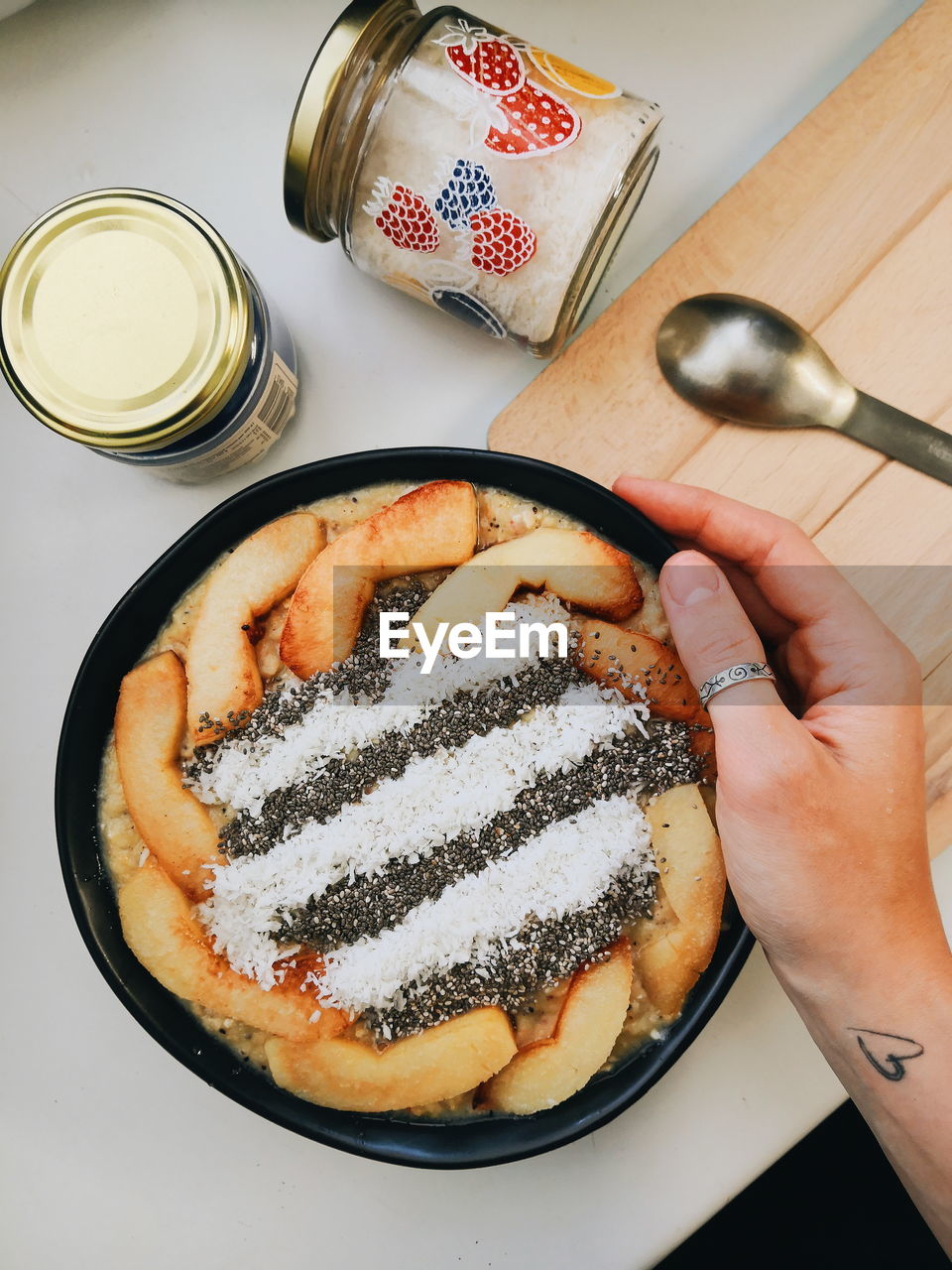 Cropped hand of woman holding breakfast on table