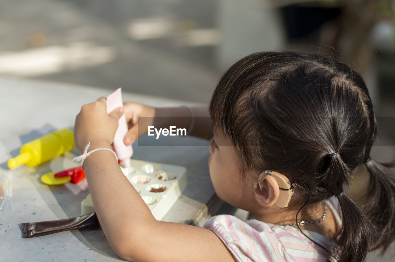 Close-up of cute girl with clay