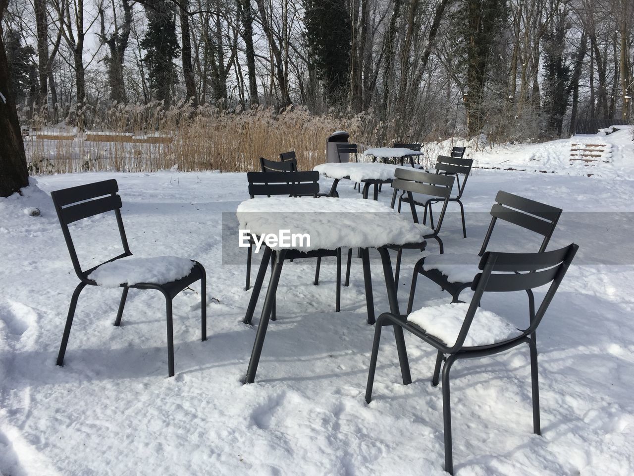 Empty chairs on frozen landscape during winter