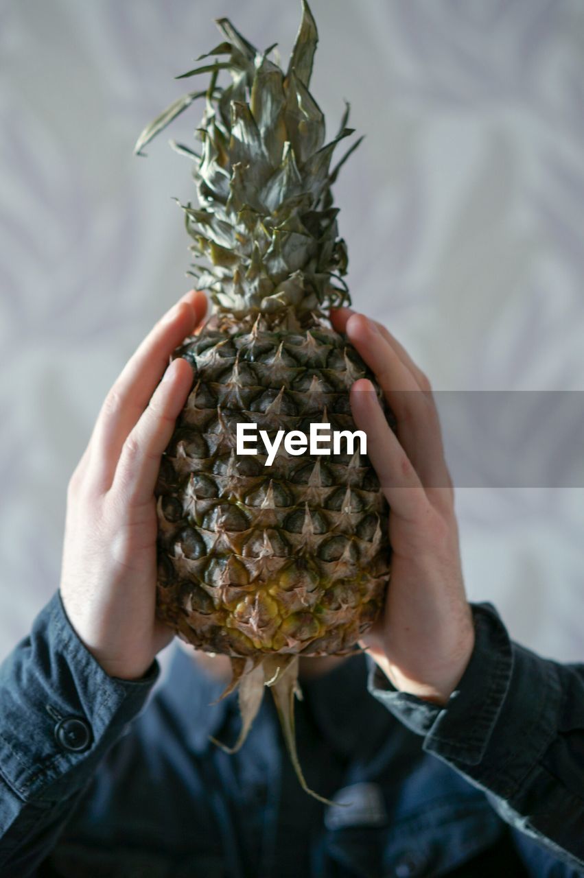 Close-up of hand holding pineapple