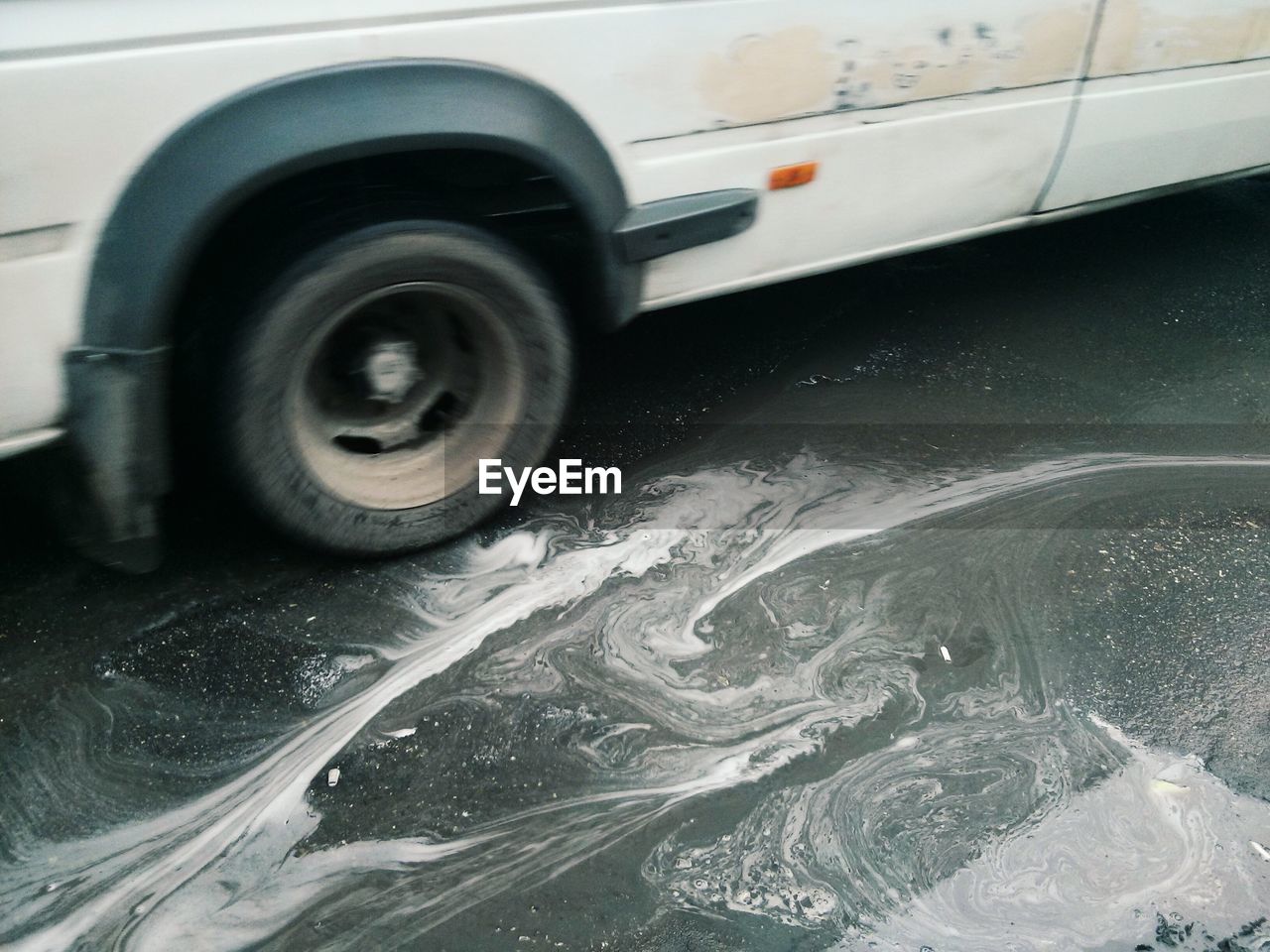 High angle view of car by puddle on street