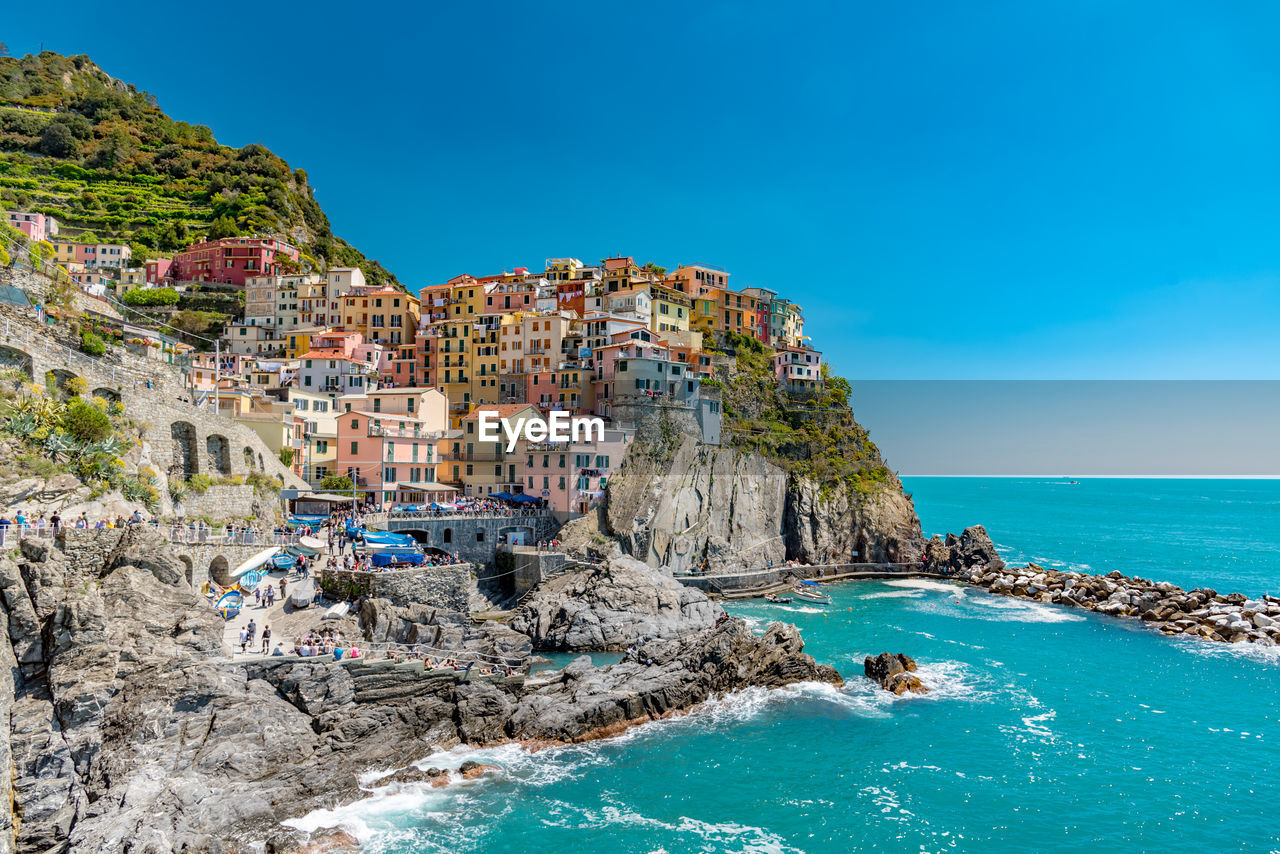 Panoramic view of manarola against clear blue sky