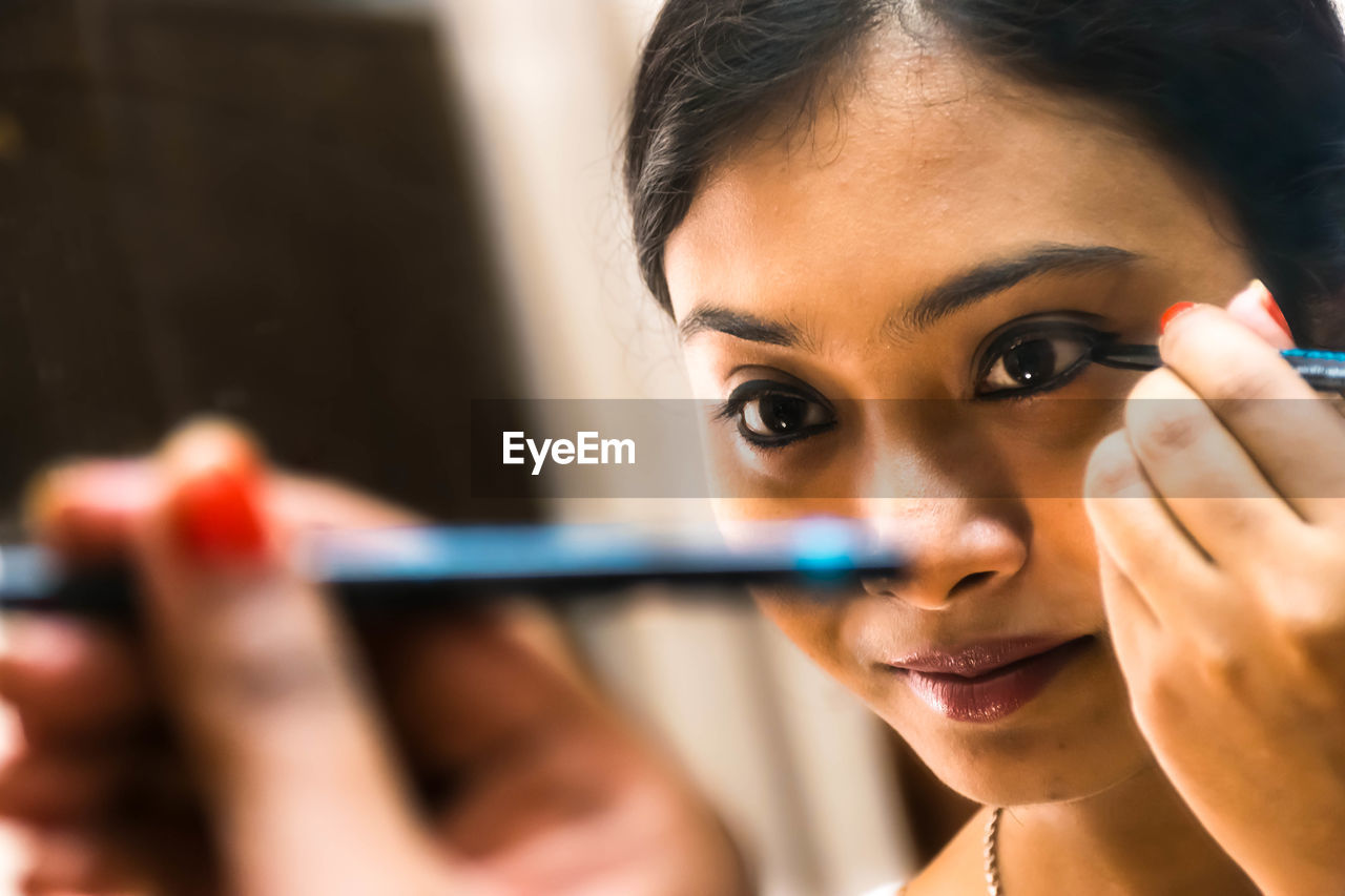 Close-up of woman applying eyeshadow