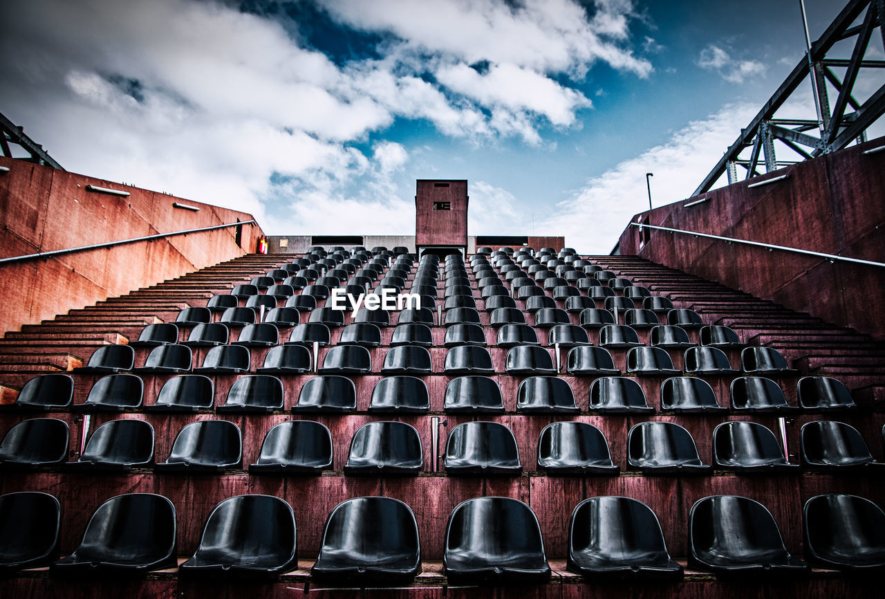 Low angle view of empty seats at stadium against sky