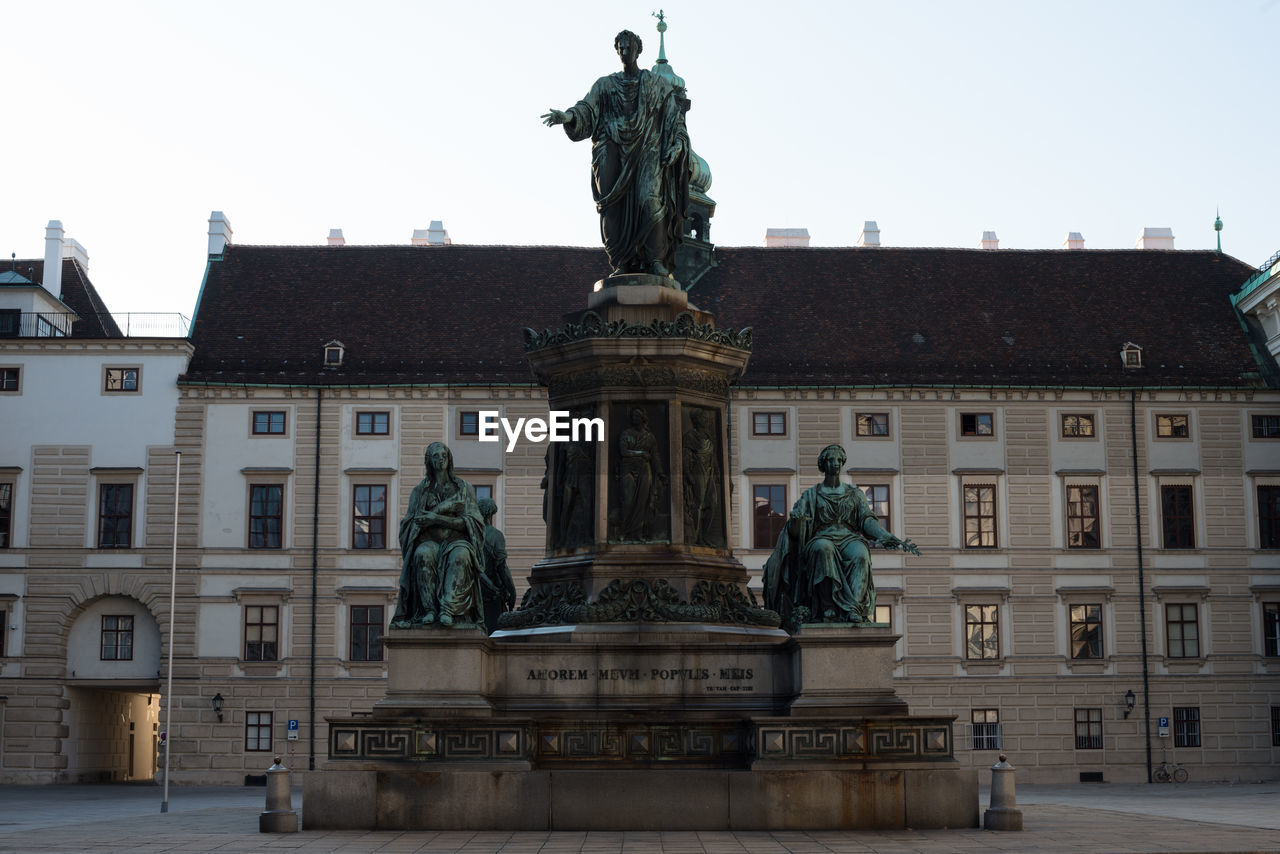 LOW ANGLE VIEW OF STATUE AGAINST BUILDING